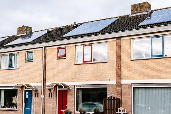 Dit is een afbeelding van referentieproject Axel. Op de afbeelding zijn rijtjeshuizen te zien met zonnepanelen op het dak.